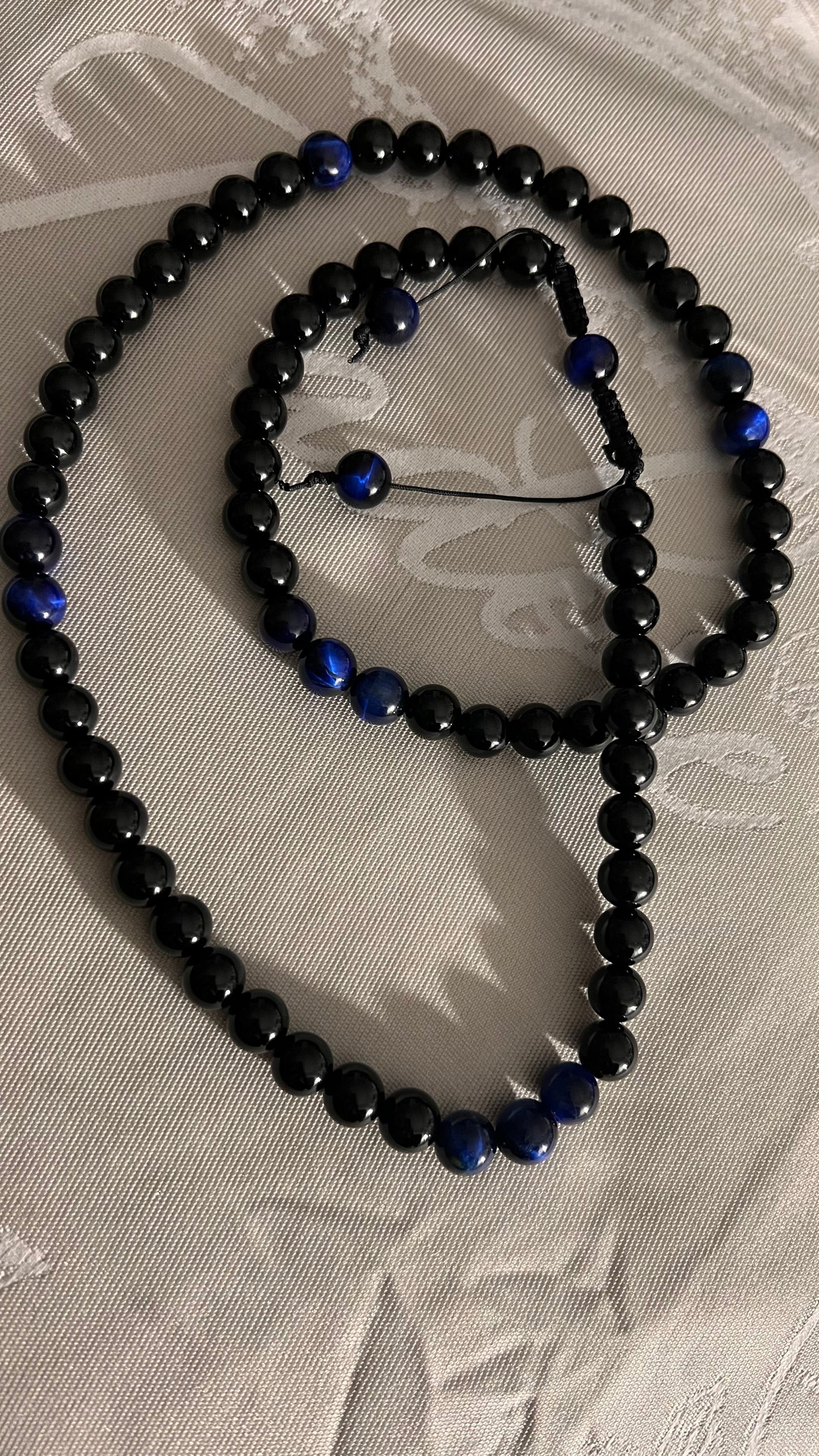 Blue Tiger Eye:  Protection, power, and perseverance/ Onyx: increase regeneration, happiness, intuition, instinctsNecklace 32” length